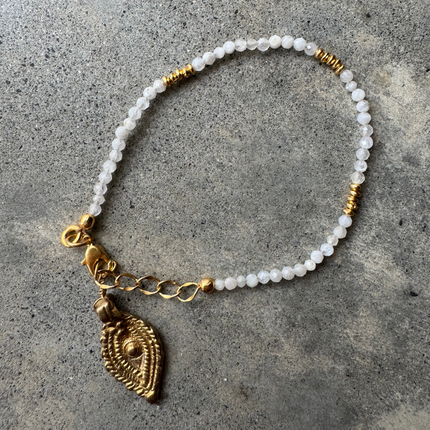 Marie Moonstone Bracelet with a brass Rajasthani charm, laid flat