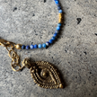 Close-up of the lapis lazuli beads and brass charm on the Marie Bracelet