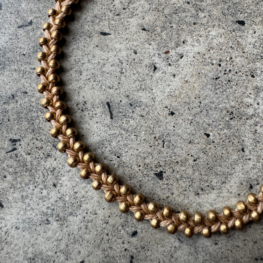 Close-up of the woven brass beads on the Nav Macrame Bracelet