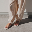 Ecru Jelly Square flip flops by Sandos worn with striped linen trousers