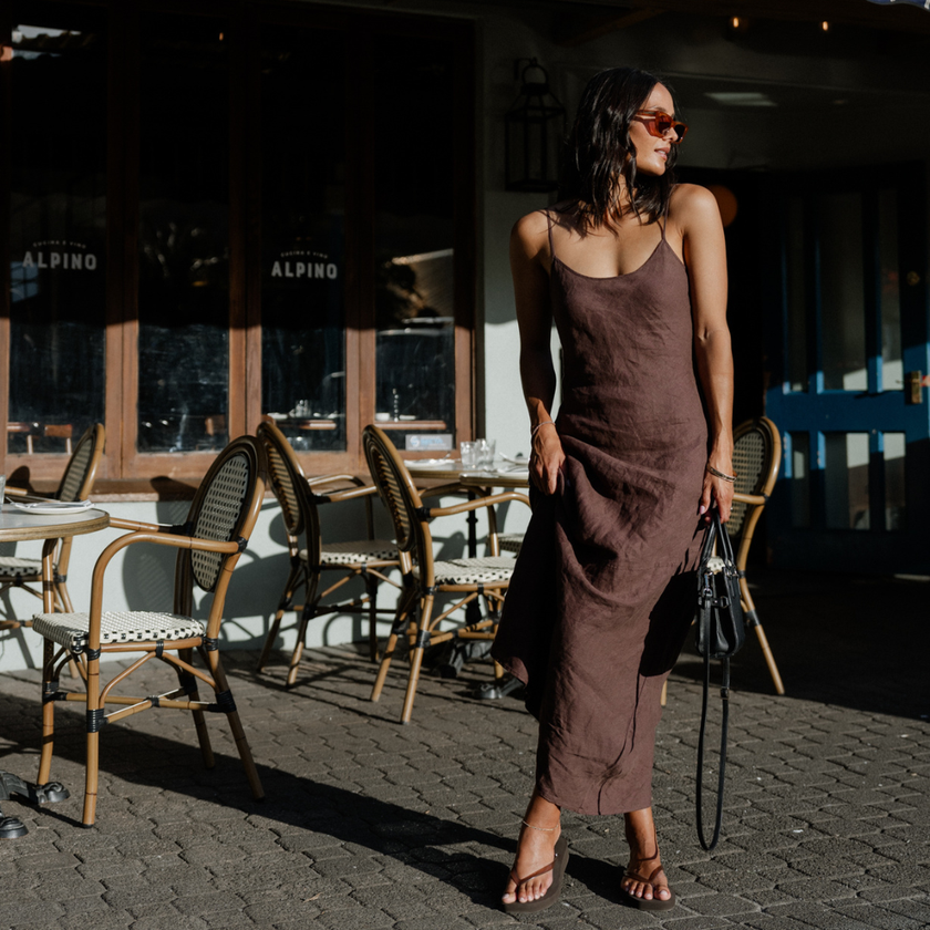 Woman in a brown slip dress outside a café wearing Espresso Jelly Tapered Platform flip flops by Sandos
