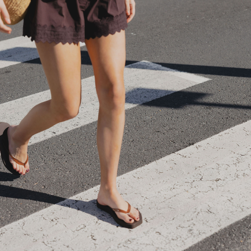 Walking across a street in Espresso Jelly Tapered Platform flip flops by Sandos