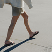 Walking down the street in Truffle Boyfriend Wide flip flops by Sandos