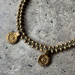 Close-up of the brass beads and charms on the Bambi Brass Anklet